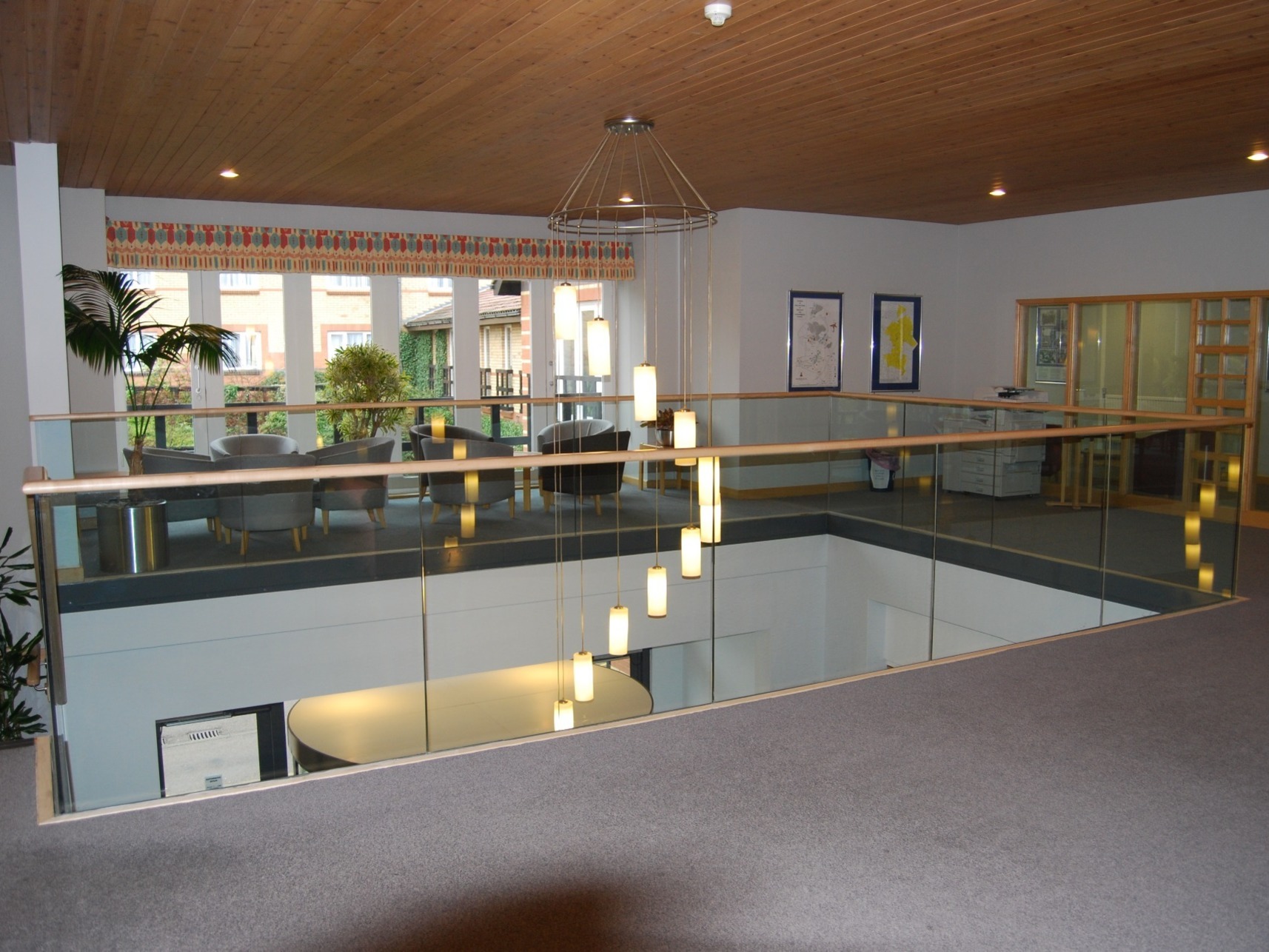 Frameless glass balustrade with timber handrail. Manufactured by Eagledale in Coventry.