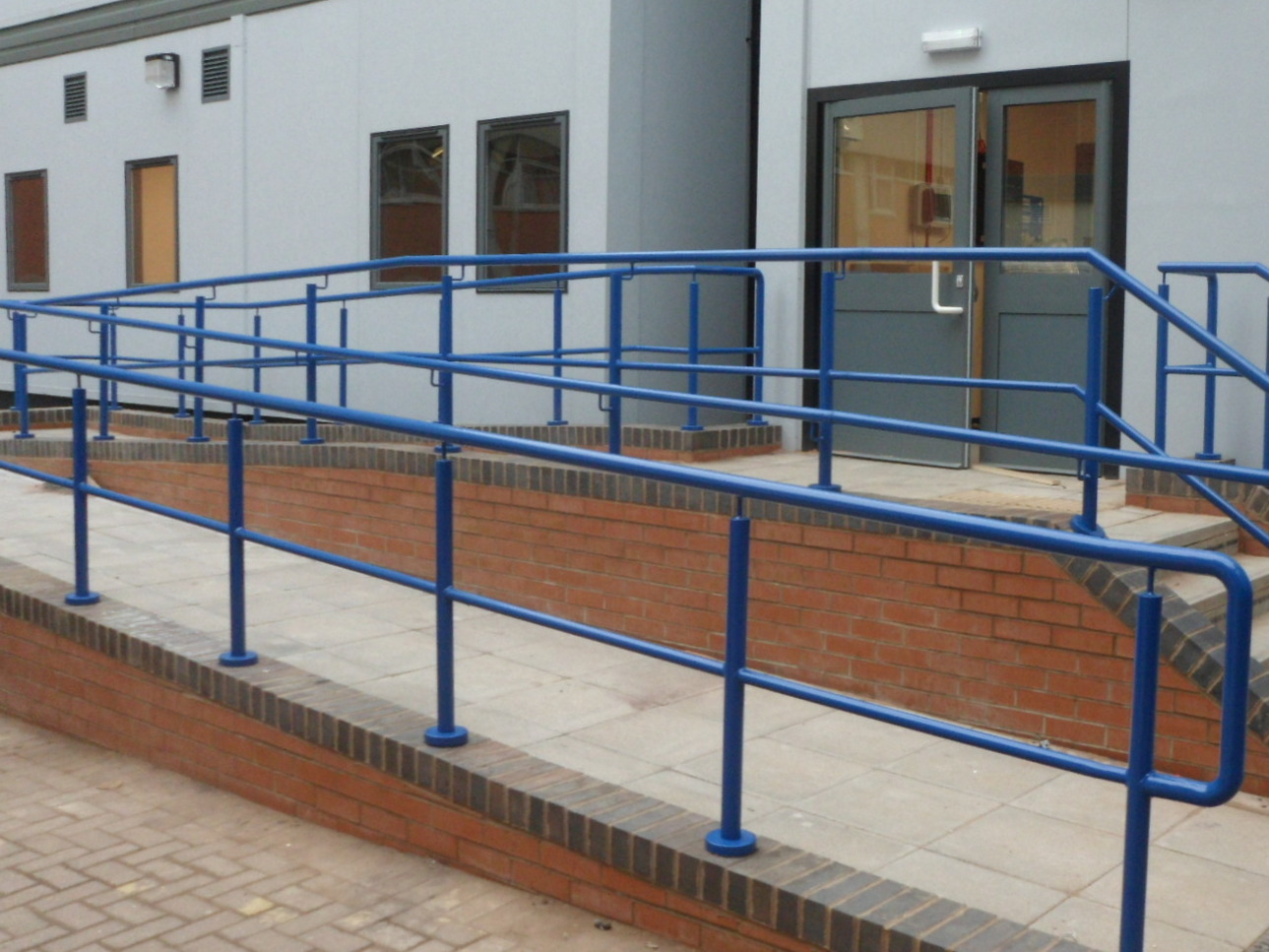 Blue ramp and step handrails with mid-rail in Coventry, West Midlands. Manufactured and installed by Eagledale.